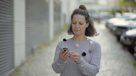 mujer de mediana edad sonriente usando un teléfono inteligente al aire libre.