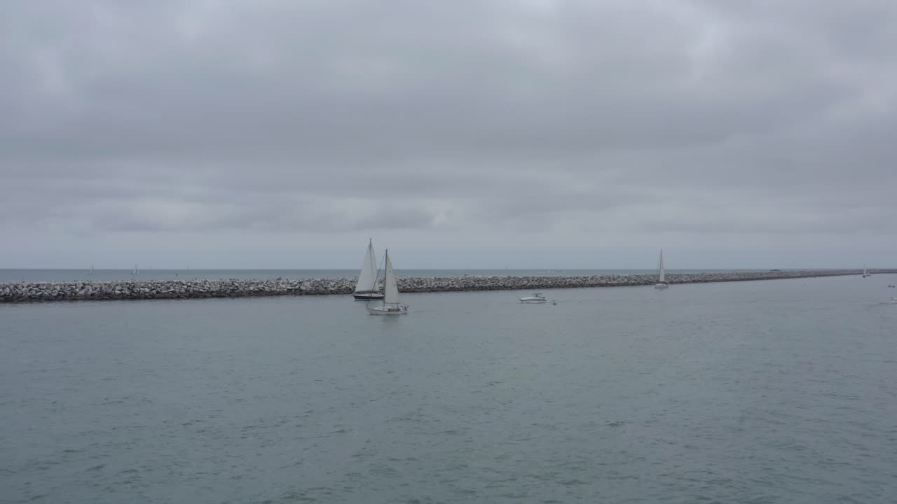 A beautiful aerial drone shot, drone flying towards and circulating sailboats, Dana Point - Orange County - California