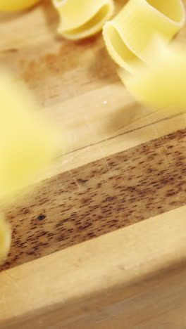 raw pasta falling on chopping board