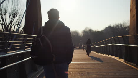 person walking on a bridge at sunset