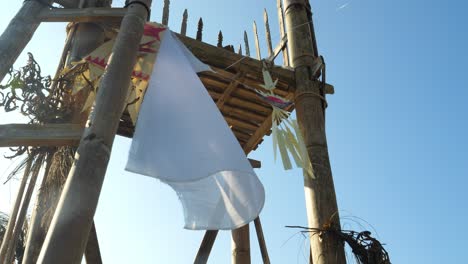 cámara lenta tomada desde un punto de vista en un templo con elementos hindúes religiosos un cazador de sueños y un paño blanco soplando en el viento durante un viaje a bali a través de indonesia