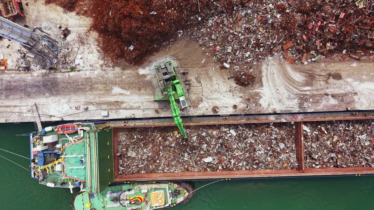 L'attività di gestione dei rifiuti si svolge in un impianto di riciclaggio vicino all'acqua in una trafficata area industriale durante le ore diurne.
