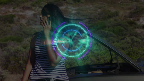 animation of pattern spinning with data over biracial woman talking on phone by broken down car