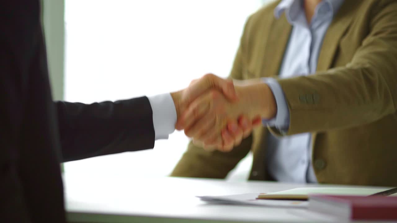 los dos hombres de negocios se dan la mano en cámara lenta.