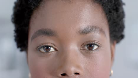 Portrait-of-happy-african-american-female-doctor-looking-at-camera-in-corridor,-slow-motion