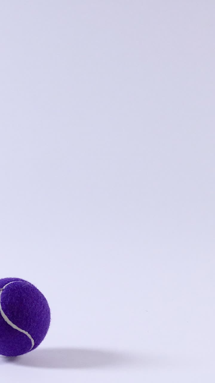 Purple tennis ball bouncing on a surface
