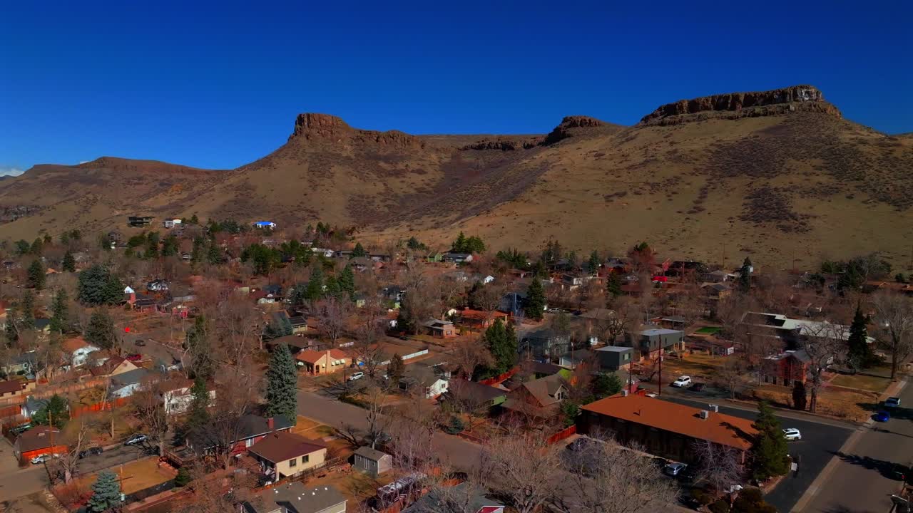 North Table Mountain Historic downtown Golden Colorado aerial drone Golden Gate Canyon winter sunny morning afternoon blue sky neighborhood homes trails mesa circle right