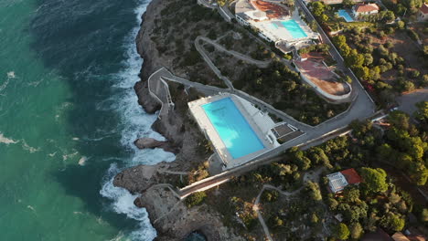 waves crashing on the rocky shore of perla del golfo resort in terrasini, province of palermo, sicilia, italy