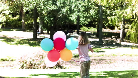 Niño-Sosteniendo-Globos-En-Cámara-Lenta