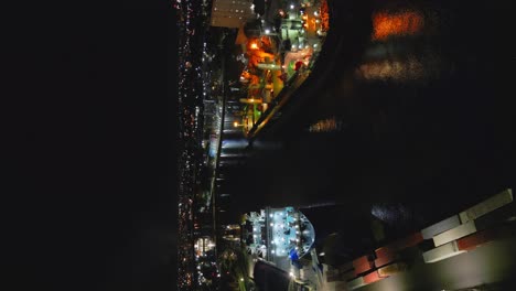 Tiro-Vertical-De-Un-Puerto-Industrial-Con-Buques-De-Carga-Y-Contenedores-Por-La-Noche