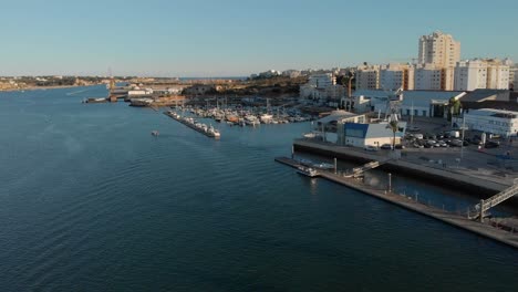Portimao-marina-aerial,-moored-boats-and-white-skyline-background-in-Algarve,-Portugal