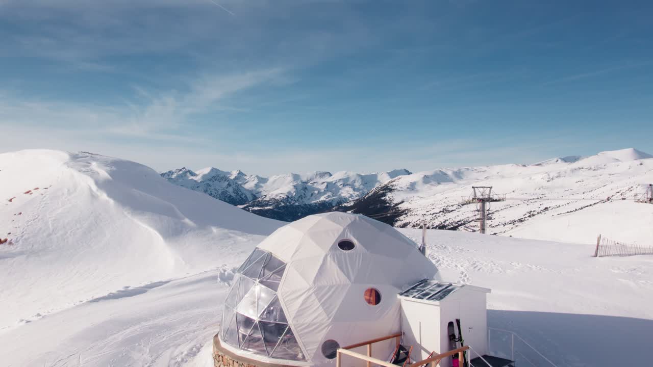 Modern mountain hut on alpine peak with ski slopes, aerial establisher