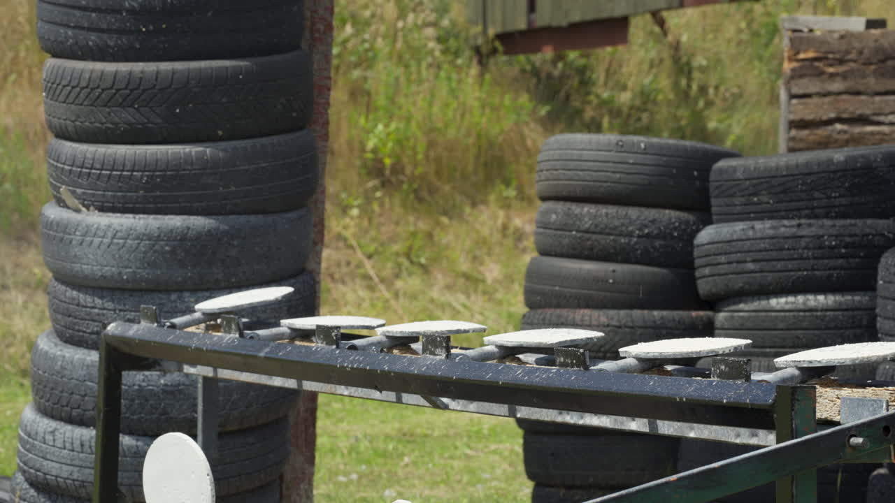 Static shot of targets being hit with bullets at gun range in the day