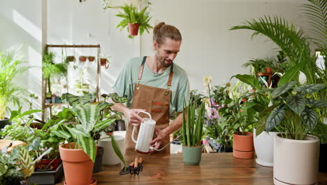 man watering plants in a plant store