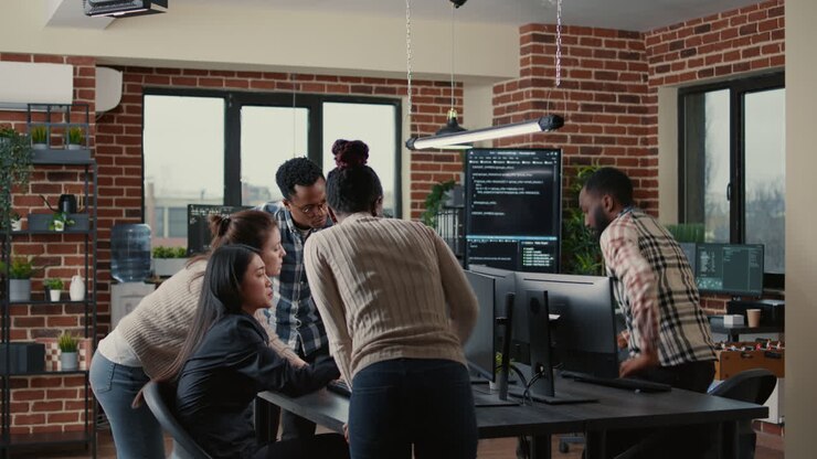 Junior dev programmers collaborating on group project compiling algorithm asking senior developer for help
