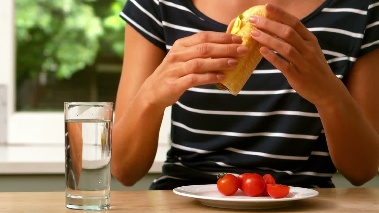 Una mujer comiendo un sándwich.
