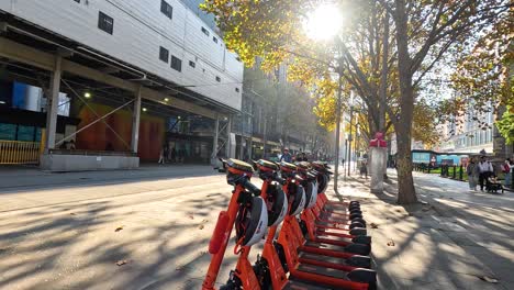 scooters lined up, people passing by