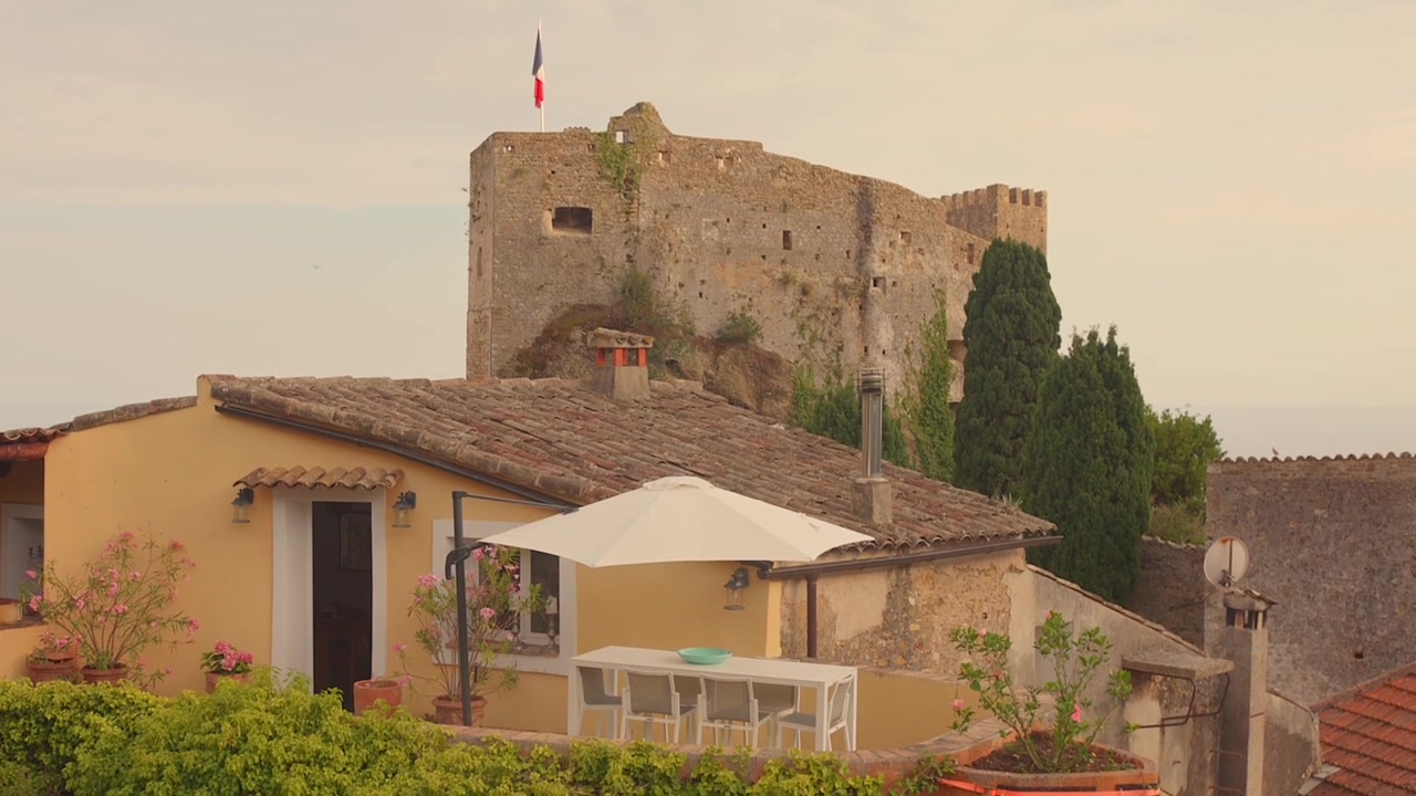 Castello medievale in pietra si erge sopra le case del villaggio e la vegetazione a Roquebrune-Cap-Martin.