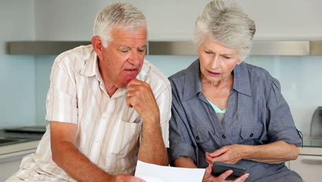 una pareja de ancianos organizando sus facturas.