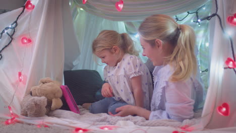 Madre-E-Hija-Pequeña-Con-Tableta-Digital-En-Un-Campamento-Casero-En-El-Dormitorio-De-Un-Niño-En-Casa---Filmadas-En-Cámara-Lenta