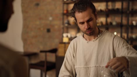 a man with a beard sits at a restaurant table