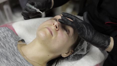 mujer recibiendo un tratamiento de inyección facial cosmética en un salón de belleza