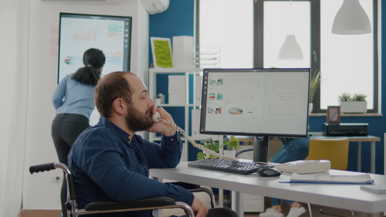 hombre de negocios inválido discapacitado sentado en silla de ruedas trabajando en la computadora