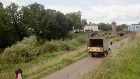 Weitwinkelaufnahme-Der-Monnow-Brücke-Neben-Dem-Monnow-Fluss-Mit-Einem-Fahrzeug-Der-Kreisverwaltung,-Das-Den-Radweg-Hinauffährt