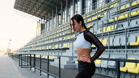 schöne sportliche frau, die sich vor dem training im freien im stadion konzentriert 2