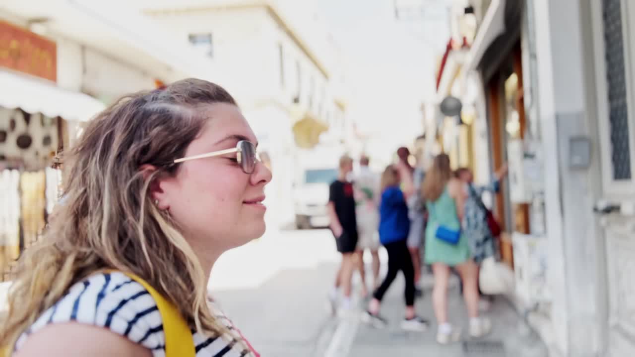 Smiling Woman Exploring a Busy Market Street in Plaka, Athens, Greece