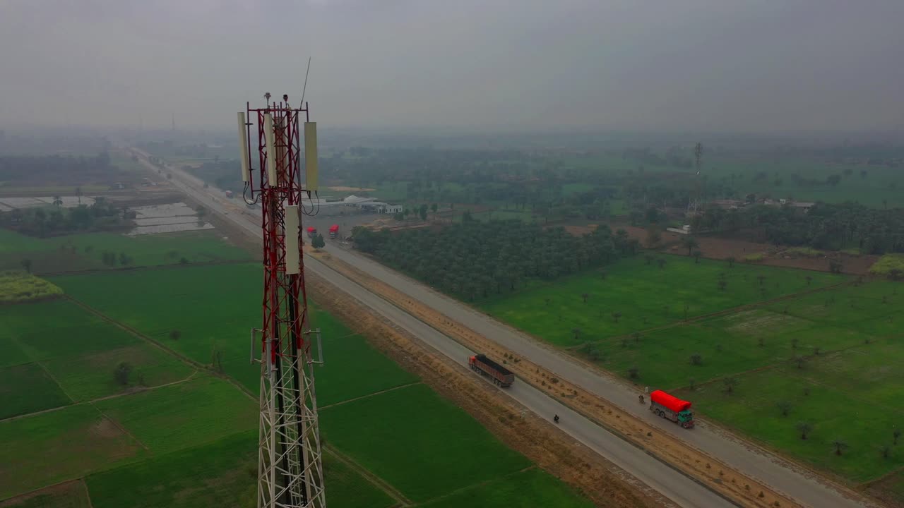 vista aérea de la torre de telecomunicaciones en khairpur sindh con campos agrícolas y tráfico de carreteras en segundo plano