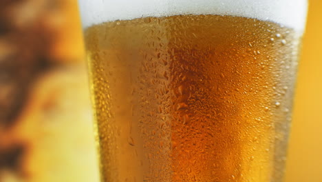 La-Cerveza-Se-Vierte-En-Un-Vaso-En-ángulo.-Ipa-De-Barril.-Cerveza-Ligera-Fría-En-Un-Vaso-Con-Gotas-De-Agua.-Cerveza-Artesanal-Formando-Olas-De-Cerca.-Frescura-Y-Espuma.-Fondo-De-La-Barra.-Cerveza-Artesanal-De-Microcervecería.