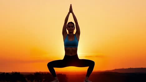 woman practicing yoga at sunset