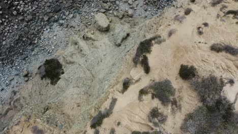tiro aéreo de nadir dolly volando sobre un acantilado que revela olas oscuras del océano que chocan contra la costa y hacia el acantilado y muchos hoodoos marinos y pilas de mar