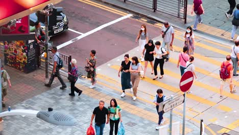 pedestrians navigate crosswalk in urban hong kong