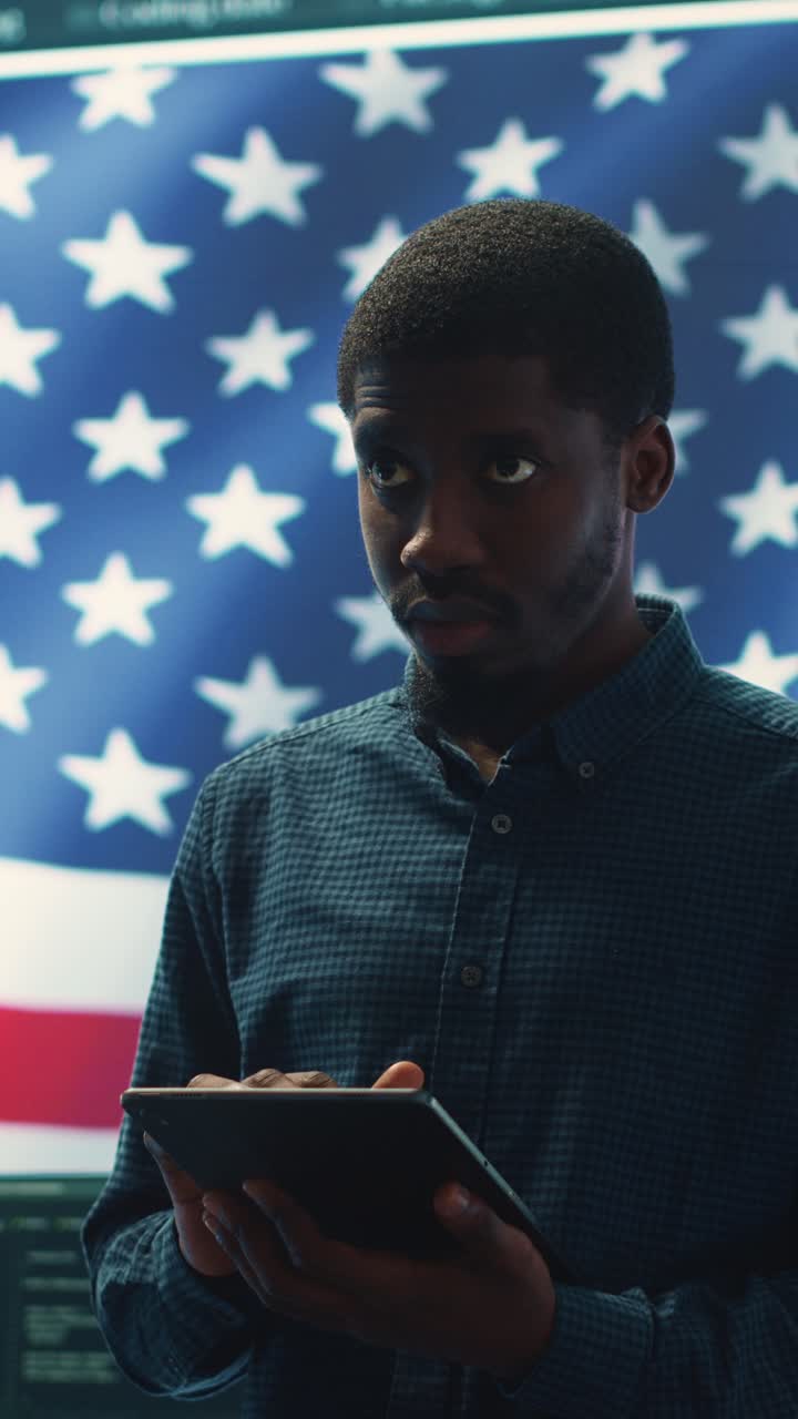 Jovem afro-americano usando tablet em frente à bandeira americana