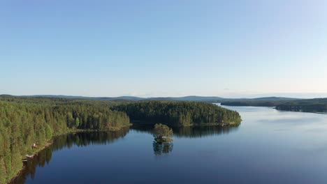 drone shot of crystal clear lake in sweden inland surrounded by deep forest landscape