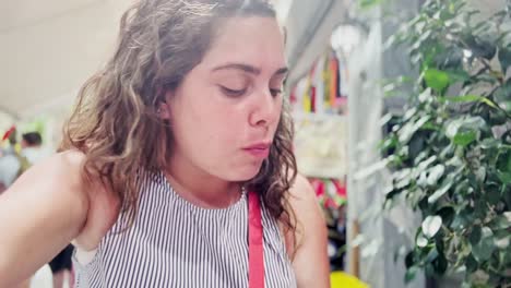 a young woman enthusiastically eats a delicious souvlaki,