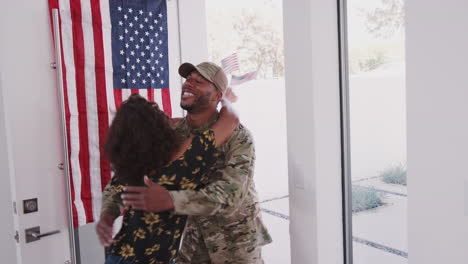 Young-mixed-race-woman-running-to-the-front-door-and-welcoming-home-her-soldier-husband