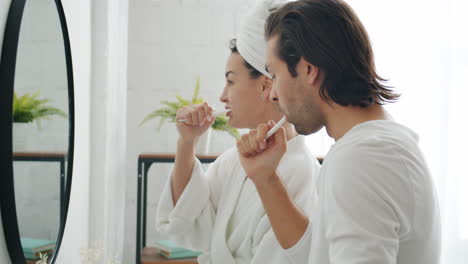 pareja cepillándose los dientes en el baño