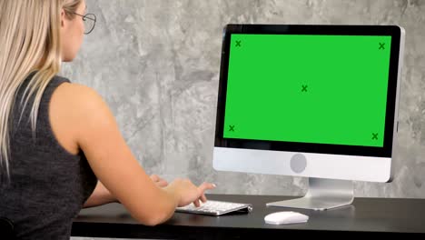 una mujer independiente está trabajando en un nuevo proyecto en la computadora. pantalla verde muestra una maqueta