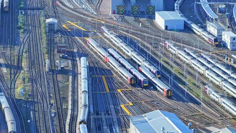 a cinematic shot above the rail tracks loaded with passenger diesel and electric passenger trains parked in the depot at derby railway station, england