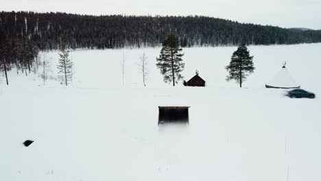 un coche eléctrico moderno pasa por un paso elevado en una carretera nevada con un lago congelado al fondo en el círculo polar ártico