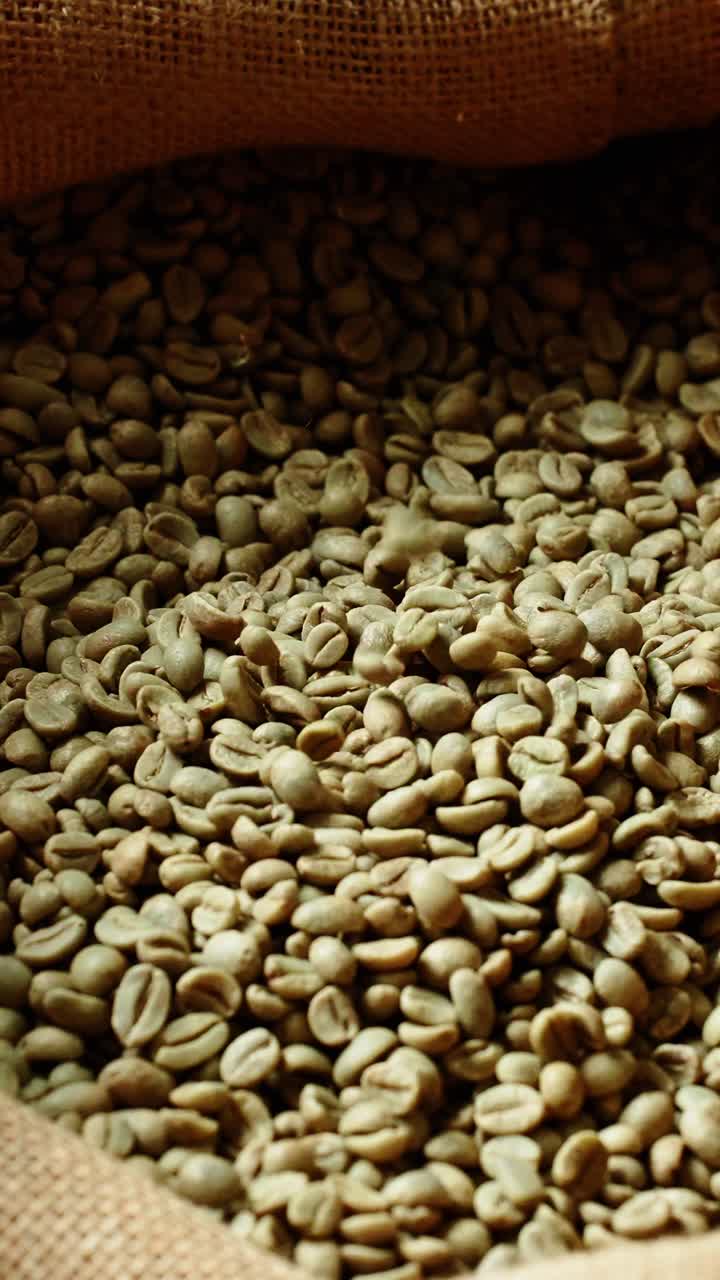 Chicchi di caffè verdi che cadono in un sacco di iuta