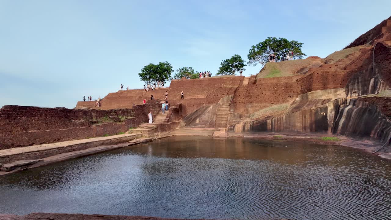 Tourists exploring the ancient ruins of sigiriya lion rock are enjoying the view of the royal swimming pool