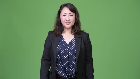 녹색 배경에 성숙한 아름다운 아시아 사업가