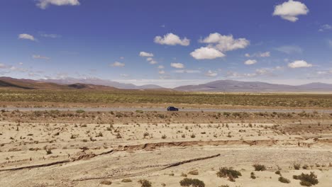 Aerial-Drone-Push-Over-Stationary-Car-In-The-Middle-Of-The-Desert