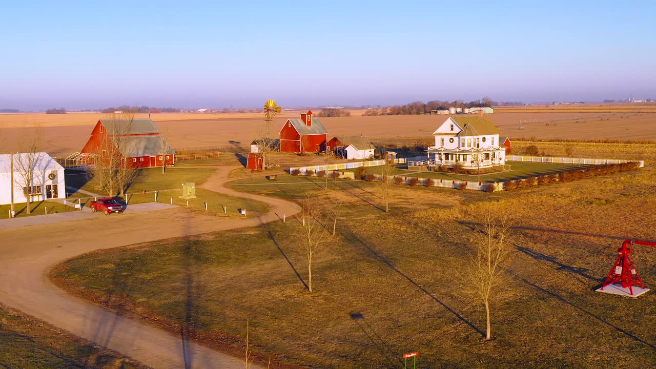 A drone aerial establishing shot over a classic farmhouse farm and barns in rural midwest America York Nebraska