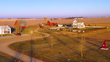 a drone aerial establishing shot over a classic farmhouse farm and barns in rural midwest america york nebraska