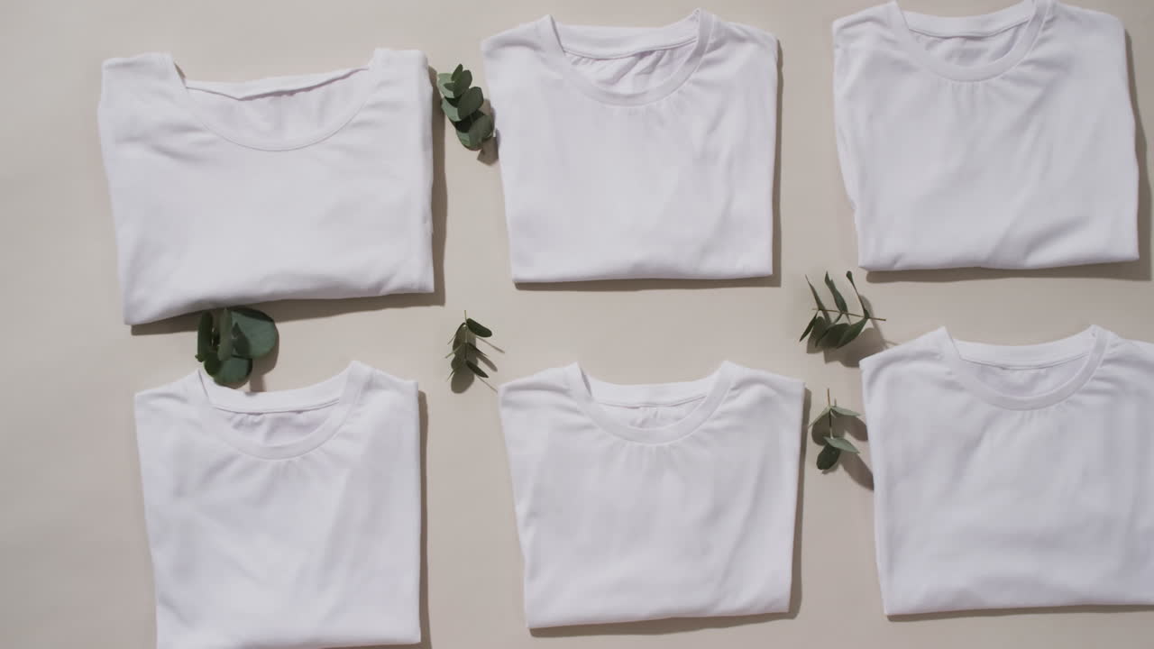 video de una capa plana de camisetas blancas plegadas con espacio de copia sobre un fondo blanco